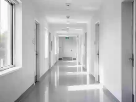 Ein heller, moderner Flur in einer Arztpraxis mit Tageslichteinfall und minimalistischer Architektur. - Foto: über boerse-global.de