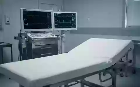 Ein steriler, leerer Untersuchungsraum in einer Klinik mit einem ausgeschalteten Herzfrequenzmonitor im Hintergrund. - Foto: über boerse-global.de