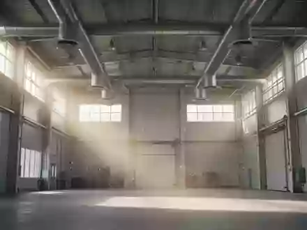 Helle, hohe Industriehalle mit sichtbaren Lüftungsschächten und einfallendem Tageslicht, in dem Staubpartikel in der Luft schweben. - Foto: über boerse-global.de