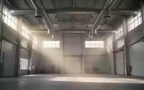 Helle, hohe Industriehalle mit sichtbaren Lüftungsschächten und einfallendem Tageslicht, in dem Staubpartikel in der Luft schweben. - Foto: über boerse-global.de