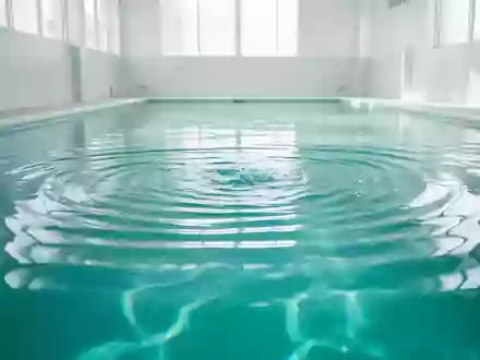 Ganzkörperansicht eines hellen, minimalistischen Schwimmbads mit klarem, türkisfarbenem Wasser und sanften Wellenbewegungen. - Foto: über boerse-global.de