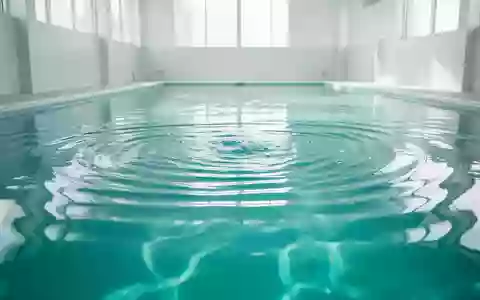 Ganzkörperansicht eines hellen, minimalistischen Schwimmbads mit klarem, türkisfarbenem Wasser und sanften Wellenbewegungen. - Foto: über boerse-global.de