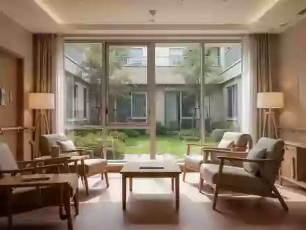 Ein helles, modern eingerichtetes Wohnzimmer in einer Seniorenwohnanlage mit Blick in einen begrünten Innenhof. - Foto: über boerse-global.de