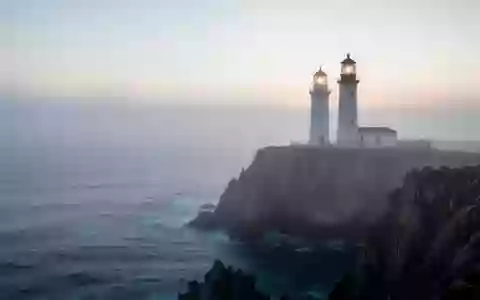 Ein Leuchtturm auf einer nebligen Klippe über dem Ozean als Symbol für Stabilität und Unterstützung. - Foto: über boerse-global.de