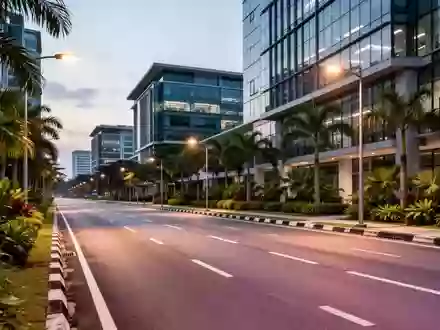 Eine leere, moderne Stadtstraße in Cyberjaya, Malaysia, umgeben von Bürogebäuden und tropischer Vegetation bei Dämmerung. - Foto: über boerse-global.de