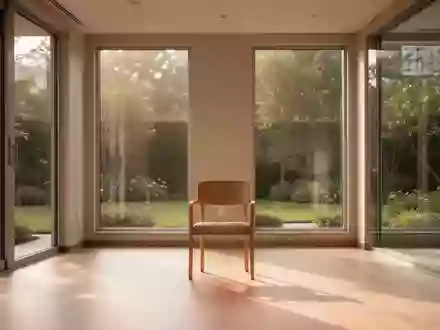 Ein heller, minimalistischer Therapieraum mit einem leeren Holzstuhl und Blick in einen ruhigen Garten. - Foto: ĂĽber boerse-global.de