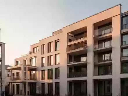 Moderne Wohnhausfassade in einer ruhigen Straße bei Sonnenuntergang. - Foto: über boerse-global.de