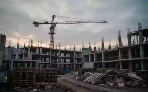 Eine stillgelegte Großbaustelle mit einem einsamen Baukran und unfertigen Betonbauten bei Dämmerung. - Foto: über boerse-global.de