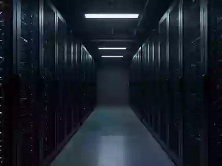 Dunkler, minimalistischer Serverraum mit metallischen Racks in kühlem blauen Licht. - Foto: über boerse-global.de