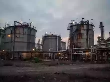 Industrielle Raffinerieanlage mit großen Stahltanks und Rohrleitungen bei Dämmerung. - Foto: über boerse-global.de