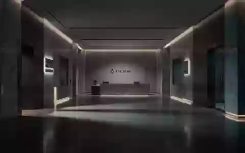 Ein schattiger, leerer Innenraum einer Bank mit polierten Steinböden und minimalistischer Architektur. - Foto: über boerse-global.de