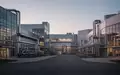 Ein modernes, ruhiges Industriegelände bei Dämmerung mit sauberer Architektur und Rohrleitungen ohne erkennbare Beschriftung. - Foto: über boerse-global.de