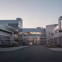 Ein modernes, ruhiges Industriegelände bei Dämmerung mit sauberer Architektur und Rohrleitungen ohne erkennbare Beschriftung. - Foto: über boerse-global.de
