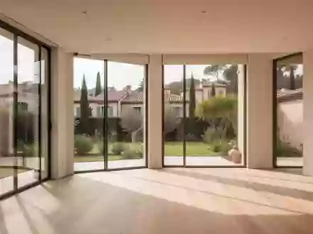 Heller, moderner Wohnraum mit großen Fenstern und Blick in einen sonnigen Garten. - Foto: über boerse-global.de