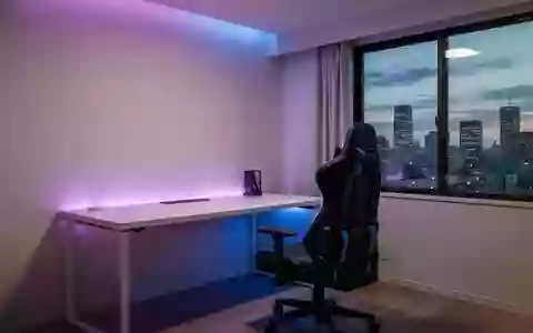 Ein minimalistisch eingerichteter Gaming-Raum mit stimmungsvoller Beleuchtung und Blick auf eine japanische Stadt bei Dämmerung. - Foto: über boerse-global.de