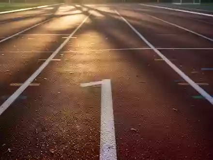 Eine leere Laufbahn bei Sonnenaufgang mit weichem Licht und Schatten auf der Kunststoffoberfläche. - Foto: über boerse-global.de