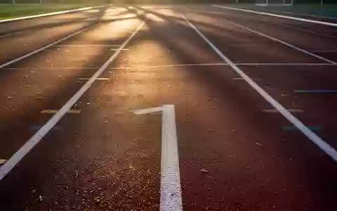 Eine leere Laufbahn bei Sonnenaufgang mit weichem Licht und Schatten auf der Kunststoffoberfläche. - Foto: über boerse-global.de