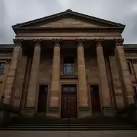 Ein monumentales, historisches Gerichtsgebäude aus Sandstein unter einem bewölkten Himmel, das Autorität und Rechtsprechung symbolisiert. - Foto: über boerse-global.de