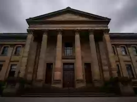 Ein monumentales, historisches Gerichtsgebäude aus Sandstein unter einem bewölkten Himmel, das Autorität und Rechtsprechung symbolisiert. - Foto: über boerse-global.de
