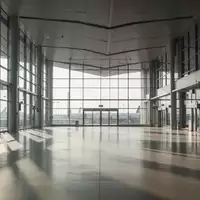 Leere, moderne Architektur einer Bahnhofshalle mit großen Glasfronten und einfallendem Tageslicht. - Foto: über boerse-global.de