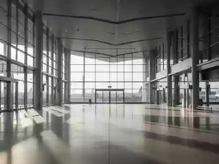 Leere, moderne Architektur einer Bahnhofshalle mit großen Glasfronten und einfallendem Tageslicht. - Foto: über boerse-global.de