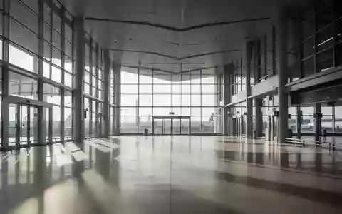 Leere, moderne Architektur einer Bahnhofshalle mit großen Glasfronten und einfallendem Tageslicht. - Foto: über boerse-global.de