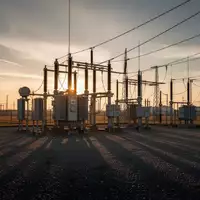 Ein Hochspannungstransformator in einem weitläufigen Industriegelände bei Sonnenuntergang. - Foto: über boerse-global.de