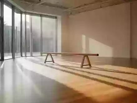 Ein minimalistisch gestalteter Fitnessraum mit hellem Holzboden und einfallendem Sonnenlicht, der eine ruhige Atmosphäre zur Körperausrichtung vermittelt. - Foto: über boerse-global.de