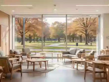 Ein heller, moderner Gemeinschaftsraum mit bequemen Sitzgelegenheiten und Blick in einen sonnigen Park. - Foto: über boerse-global.de