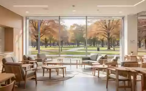 Ein heller, moderner Gemeinschaftsraum mit bequemen Sitzgelegenheiten und Blick in einen sonnigen Park. - Foto: über boerse-global.de