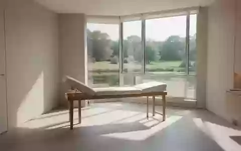 Ein heller, minimalistischer Behandlungsraum in einer Klinik mit Blick ins Grüne und weichem Tageslicht. - Foto: über boerse-global.de