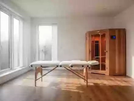 Ein heller, minimalistisch eingerichteter Raum für Gesundheitsprävention mit einer Massageliege und einer Infrarotkabine. - Foto: über boerse-global.de