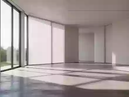 Ein minimalistischer, moderner Innenraum mit natürlichem Lichteinfall und klaren geometrischen Schatten auf einem Betonboden. - Foto: über boerse-global.de