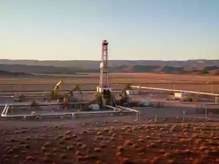 Industrielle Bohranlage in einer weiten Beckenlandschaft bei Sonnenuntergang. - Foto: über boerse-global.de