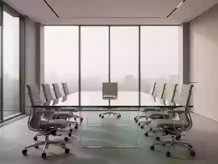 Ein minimalistischer, moderner Konferenzraum mit einem leeren Glastisch und ergonomischen Stühlen bei natürlichem Tageslicht. - Foto: über boerse-global.de