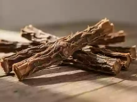 Nahaufnahme von getrockneten Süßholzwurzeln auf einem hölzernen Untergrund mit natürlichem Lichteinfall. - Foto: über boerse-global.de