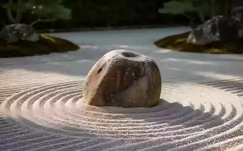 Ein minimalistischer Zen-Garten mit geharktem Sand und einem glatten Stein als Symbol für Ruhe und bewusste Atmung. - Foto: über boerse-global.de