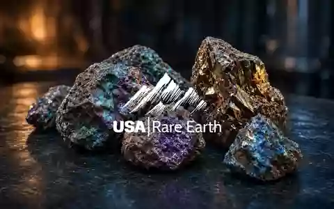 Nahaufnahme von glänzenden Seltenerdmineralien auf dunklem Stein vor einem stimmungsvollen, tiefblauen Hintergrund. - Foto: über boerse-global.de