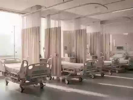Ein heller, steriler Behandlungsraum in einer Klinik mit leeren Betten und Sichtschutzvorhängen. - Foto: über boerse-global.de