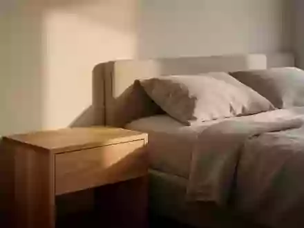 Modernes Schlafzimmer im sanften Morgenlicht mit einem minimalistischen Nachttisch aus Eichenholz. - Foto: ĂĽber boerse-global.de