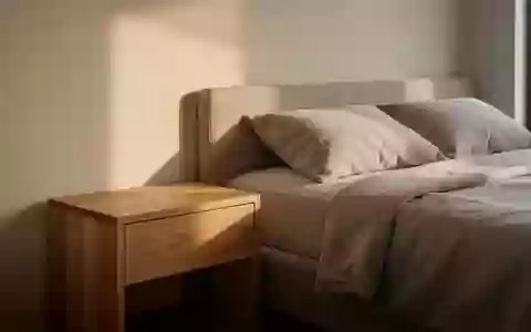 Modernes Schlafzimmer im sanften Morgenlicht mit einem minimalistischen Nachttisch aus Eichenholz. - Foto: über boerse-global.de