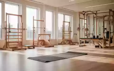 Ein minimalistischer, heller Trainingsraum mit hochwertigen Sportgeräten auf einem Holzboden in natürlichem Tageslicht. - Foto: über boerse-global.de