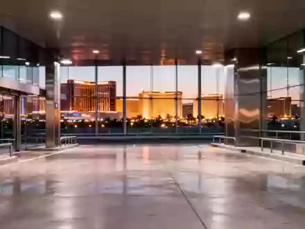 Eine menschenleere, moderne Abholzone in einem Flughafen bei Dämmerung mit Blick auf die Lichter der Stadt Las Vegas. - Foto: über boerse-global.de