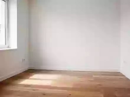 Ein minimalistisch eingerichteter, sonnendurchfluteter Arbeitsbereich in einer kleinen Wohnung. - Foto: über boerse-global.de