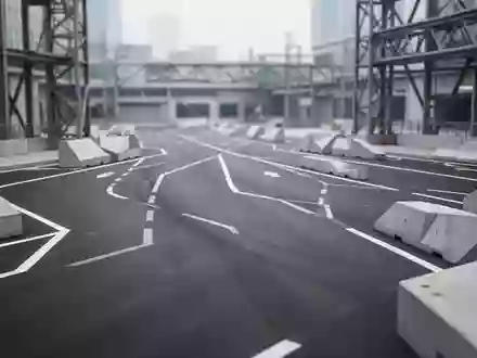 Ein modernes, leeres Testgelände für autonome Fahrsysteme mit Markierungen auf dem Asphalt und architektonischen Strukturen. - Foto: über boerse-global.de