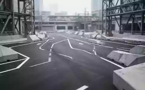 Ein modernes, leeres Testgelände für autonome Fahrsysteme mit Markierungen auf dem Asphalt und architektonischen Strukturen. - Foto: über boerse-global.de