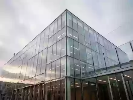 Moderne Glasfassade eines Bürogebäudes bei bewölktem Himmel in Berlin. - Foto: über boerse-global.de