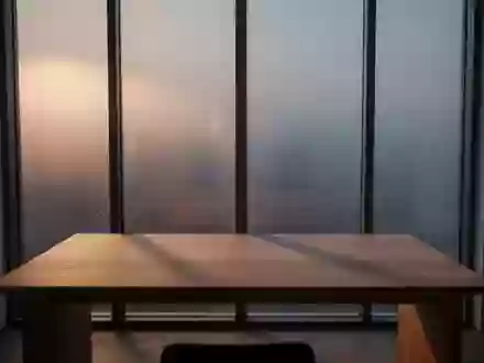 Ein minimalistischer, ruhiger Arbeitsplatz mit einem leeren Holztisch vor einem Fenster, das sanftes Tageslicht einlässt. - Foto: über boerse-global.de