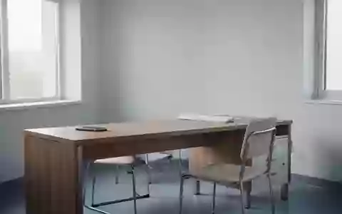 Ein minimalistisches, unbesetztes Arztzimmer mit einem Schreibtisch und einem Stuhl bei natürlichem Tageslicht. - Foto: über boerse-global.de