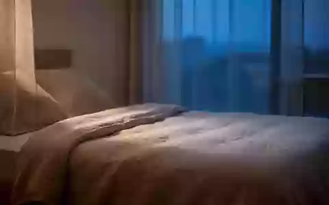 Ein minimalistisch eingerichtetes Schlafzimmer in den frühen Morgenstunden mit natürlichem, sanftem Licht. - Foto: über boerse-global.de
